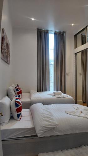 a bedroom with two beds and a window at Cozy Apartment Sleep 5 in Berkely BK3 in London