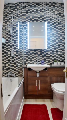 a bathroom with a sink and a tub and a toilet at Cozy Apartment Sleep 5 in Berkely BK3 in London