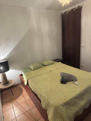 Un dormitorio con una cama con un edredón verde. en Chambre zen confort et simple Sans Climatisation, en Saint-Pierre