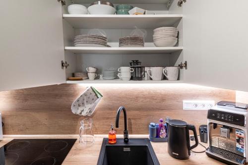 a kitchen with a sink and a counter with dishes at Apartmán Horček, Terchová in Terchová