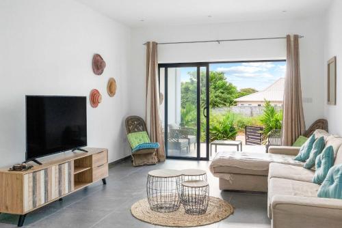 a living room with a tv and a couch at Ayana Flat - Perfect West Coast Stay in Tamarin