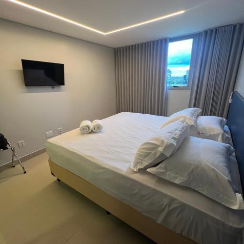 a bedroom with a bed with two towels on it at Hotel Salute in Taguatinga