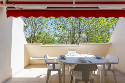 une table et des chaises dans une pièce avec une grande fenêtre dans l'établissement Grand studio climatisé à la mer avec garage privé, à La Grande Motte