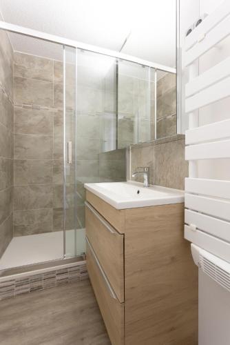 une salle de bain avec un lavabo et une douche dans l'établissement Grand studio climatisé à la mer avec garage privé, à La Grande Motte