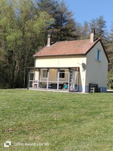 une maison blanche avec une pelouse et des arbres dans l'établissement gîte de campagne, à Chantenay-Saint-Imbert