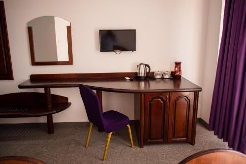 a desk with a mirror and a purple chair at Royal by Euxin in Constanţa