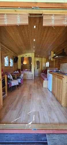 Habitación grande con suelo de madera y habitación grande con cocina. en Roulotte du Soleil - Mas du Soleil, en Eyragues