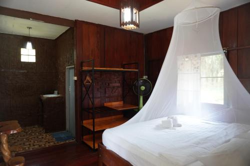 a bedroom with a white bed and a window at Khao Sok Palmview Resort in Khao Sok