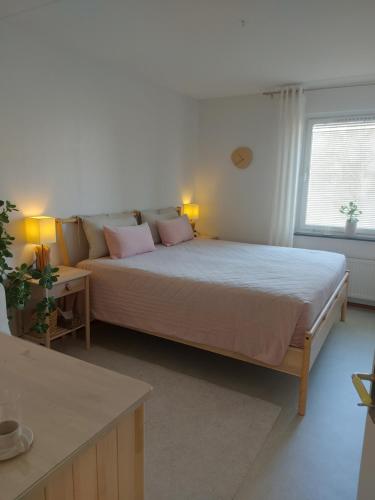 a bedroom with a large bed with pink pillows at feel like your own home in Stockholm