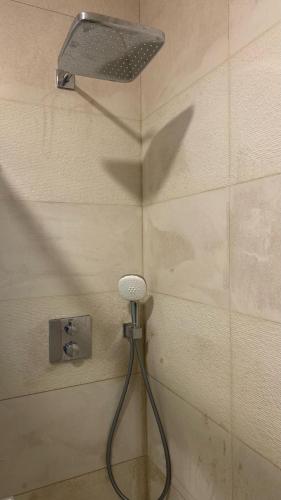 a shower with a shower head on a wall at Margarida Guest House - Rooms Lisbon South by Rosado in Almada