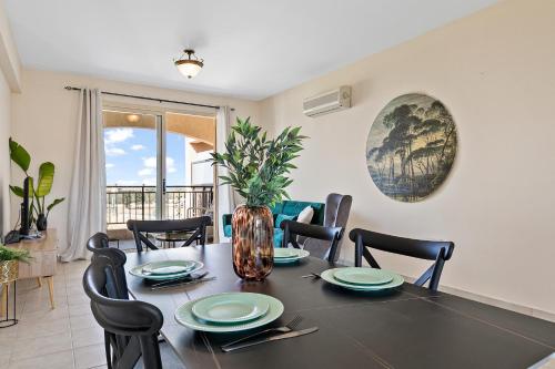 a dining room with a black table and chairs and a table and chairsktop at Royal Seacrest amazing location 2 Bed Apartment by VICHY Holidays in Paphos