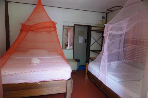 a room with two beds with nets on them at Khao Sok Palmview Resort in Khao Sok
