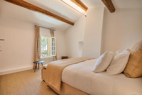 een slaapkamer met een groot bed en een raam bij Propriété d'exception - Piscine et Tennis in Venelles