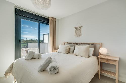 Un dormitorio con una cama con una ventana grande. en Casa Aranya, en Estepona