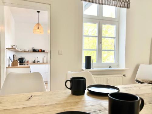 a kitchen and dining room with a wooden table at Neu MAKERS and ROOMS APARTMENTS Rosental am Schlosspark Detmold in Detmold