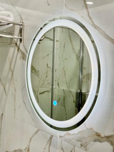 a round mirror on a wall in a bathroom at Velvet Aura Jacuzzi Edessa in Edessa