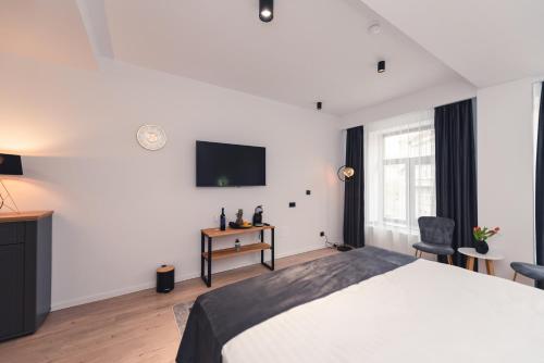 a bedroom with a bed and a tv on the wall at Ataraxya Premium Residence Old Town in Braşov