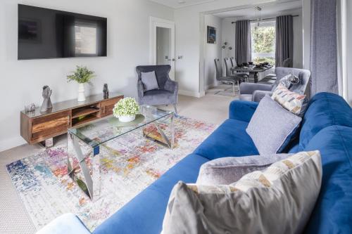 a living room with a blue couch and a table at Quiet 2 bedroom gem in Stirling in Bridge of Allan