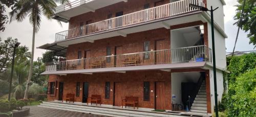a building with balconies and tables on it at DOLPHIN ENCLAVE SERVICE STUDIO APARTMENTS in Kalpetta