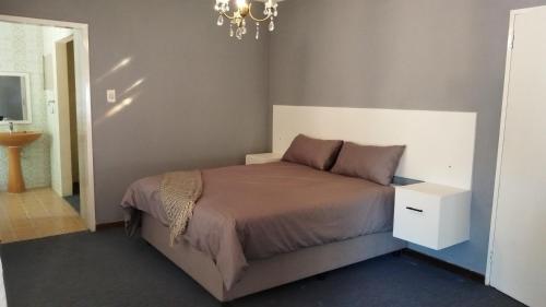 a bedroom with a bed and a chandelier at KSG GuestFarm in Eikenhof