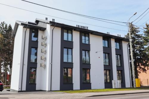 a white and black building on a street at W64 Apartamenty in Płock