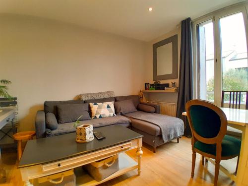 un salon avec un canapé et une table dans l'établissement Maison T3, Invitation au voyage, Jardinet, Parking, à Houilles