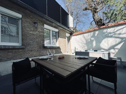 une table en bois sur une terrasse avec deux chaises dans l'établissement 2 Lenoir T2 spacieux avec jacuzzi au centre-ville, à Reims
