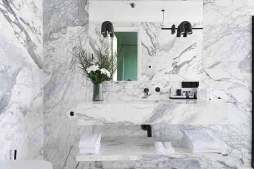 a white marble bathroom with a sink and a mirror at Tsinandali Estate, A Radisson Collection Hotel in Tsinandali