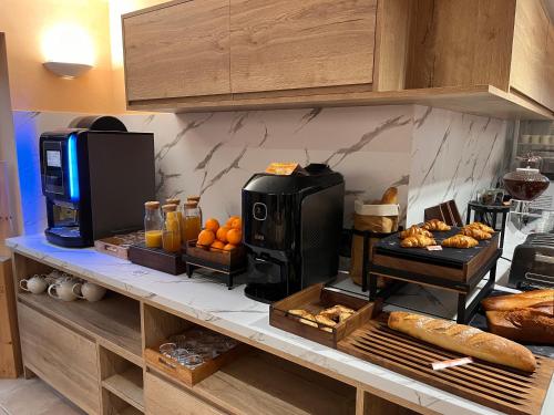 a kitchen with a counter with bread and a coffee maker at Logis Hotel Spa Restaurant Le Provence in Lanarce