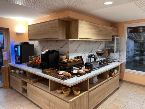 a kitchen with a bunch of food on a counter at Logis Hotel Spa Restaurant Le Provence in Lanarce