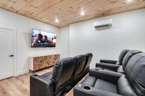 a living room with leather chairs and a flat screen tv at Spring Splash Retreat - Pool Hot Tub & Games in Catlettsburg