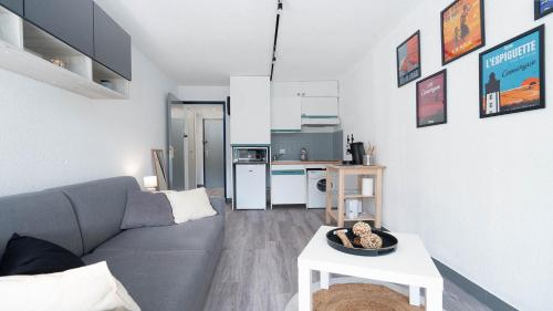 un salon avec un canapé et une table et une cuisine dans l'établissement LA LAGUNE -105- Studio cabine 4 pers, au Grau-du-Roi