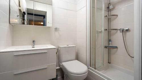 une salle de bain blanche avec toilettes et douche dans l'établissement LA LAGUNE -105- Studio cabine 4 pers, au Grau-du-Roi