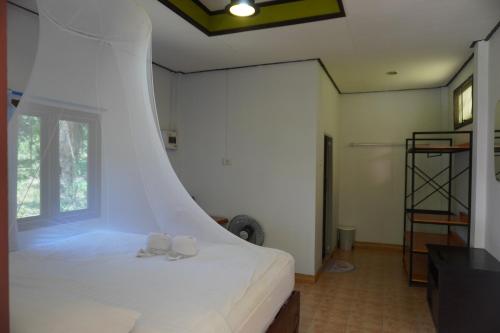 a bedroom with a bed with white sheets and a window at Khao Sok Palmview Resort in Khao Sok