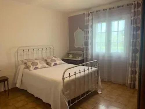 une chambre avec un lit blanc et une fenêtre dans l'établissement Villa familiale avec piscine à Milhaud - 100 m²_2, à Milhaud