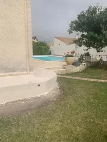 une maison avec une fenêtre et une cour avec une piscine dans l'établissement Villa familiale avec piscine à Milhaud - 100 m²_2, à Milhaud