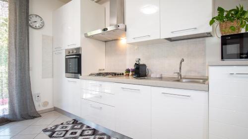 a white kitchen with white cabinets and a sink at Lovely and Quite - Bosa by Sardinianworld in Bosa