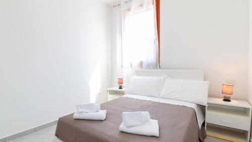 a white bedroom with a bed with two white towels at Lovely and Quite - Bosa by Sardinianworld in Bosa