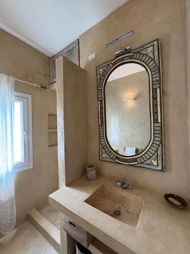 a bathroom with a large mirror and a sink at Casa Sanaa - Sea view in Watamu