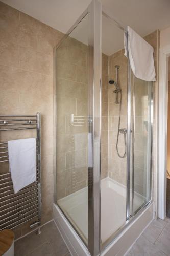 a shower with a glass door in a bathroom at 3-Bed Home Near Town Center in Stirling