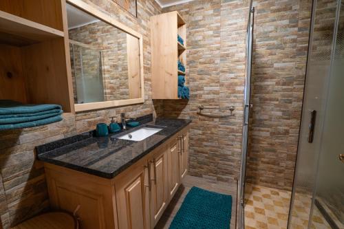 a bathroom with a sink and a shower at Apartamento Escadinhas do Castelo in Monchique