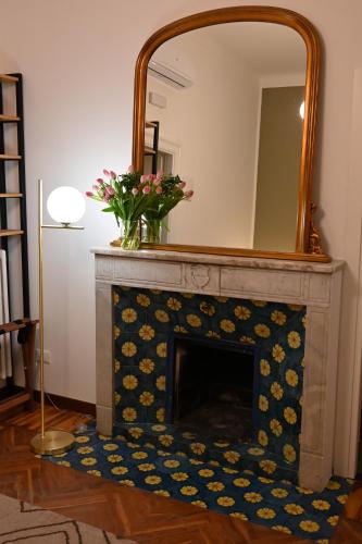 a fireplace with a mirror on top of it at Villa del Parco in Poggi