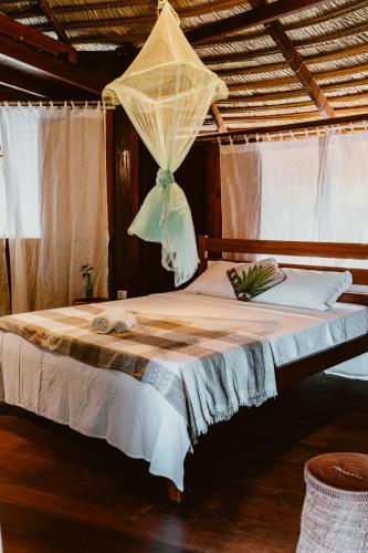 a bed with a net on top of it at Villa Arapiuns - 6 Bangalôs na Floresta in Santarém