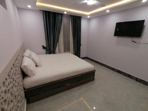 a bedroom with a bed and a flat screen tv at Mount Murree Hotel in Murree