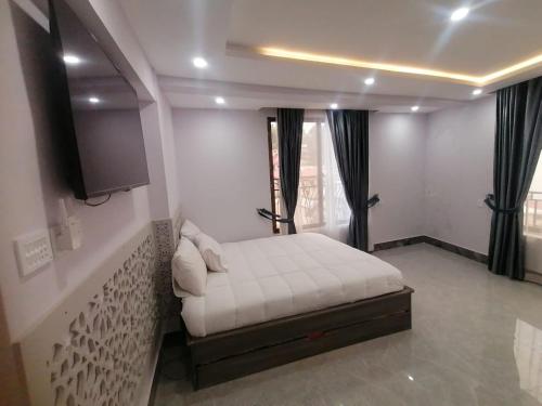 a bedroom with a white bed and a window at Mount Murree Hotel in Murree