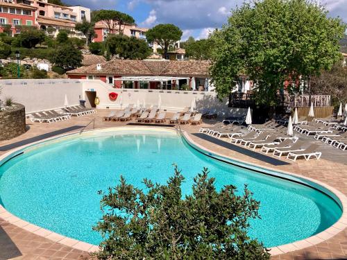 une grande piscine entourée de chaises longues. dans l'établissement Les Restanques Lavandes 2009 rez de jardin, à Grimaud
