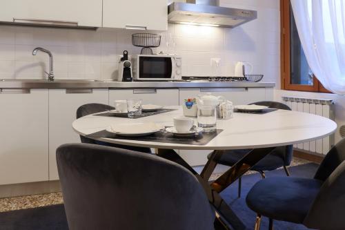 a kitchen with a white table with chairs and a microwave at Relais Venezia in Venice