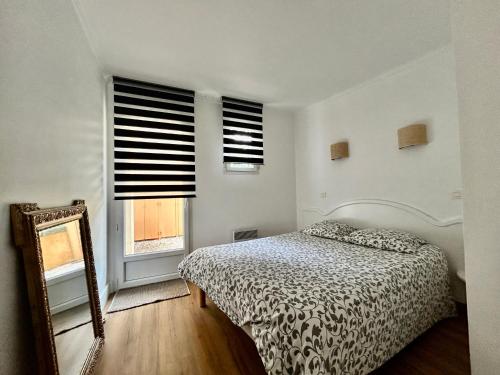 une chambre avec un lit, un miroir et une fenêtre dans l'établissement Les Restanques Lavandes 2009 rez de jardin, à Grimaud