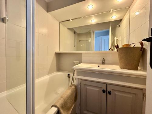 une salle de bain avec une baignoire, un lavabo et un miroir dans l'établissement Les Restanques Lavandes 2009 rez de jardin, à Grimaud