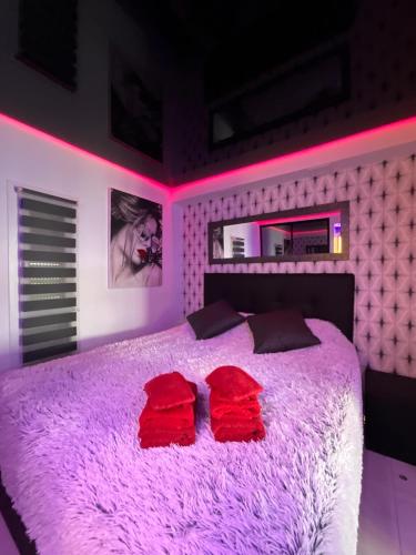 - une chambre rose avec un grand lit et des oreillers rouges dans l'établissement Portnature 571 Cap d'Agde Naturiste, au Cap d'Agde